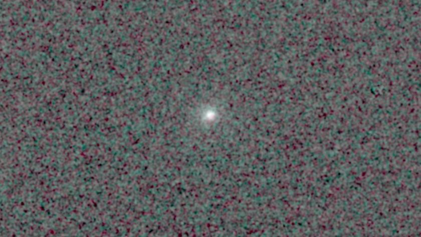 Comet 3I/ATLAS is feasible as a bright point of glowing light in the center of a pixelated black and dark grey background.