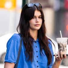 Kaia Gerber makes pirate-core a thing in jean shorts, a button-down, and boots in the summer.