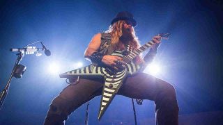 Zakk Wylde wearing a bowler hat and performing onstage in 2016