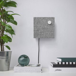 white room with bluetooth speakers and potted plant