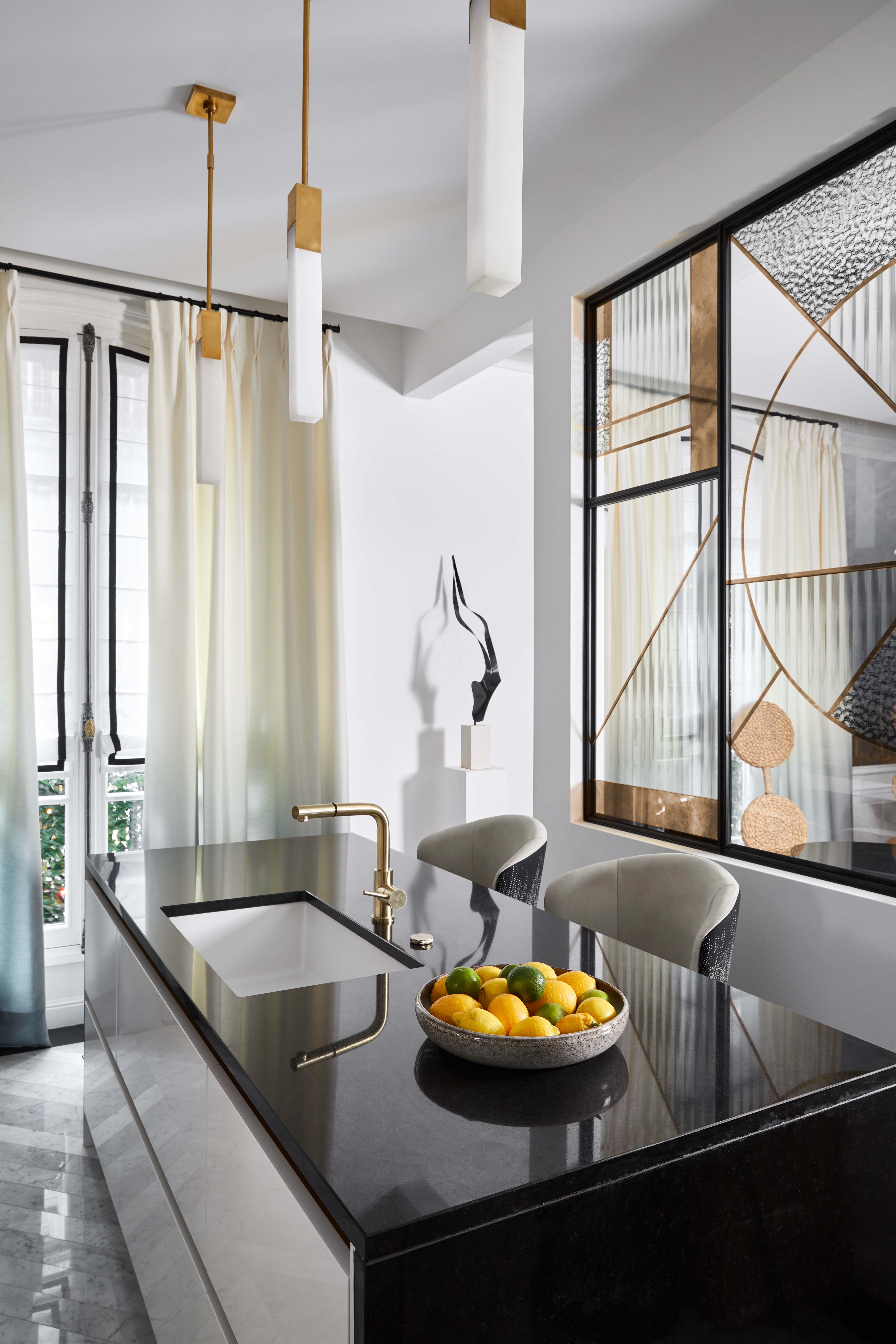 a glossy black kitchen with an art deco inspired glass insert between the walls.