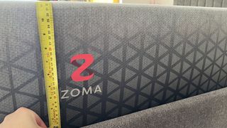 Zoma Hybrid with tape measure showing depth of mattress