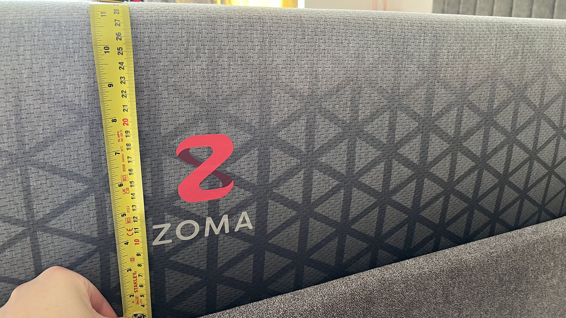 Zoma Hybrid with tape measure showing depth of mattress