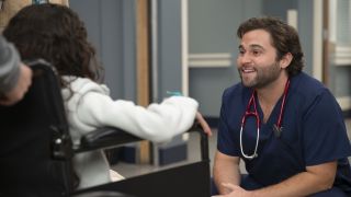 Jake Borelli as Levi Schmitt talks to a young patient on Grey's Anatomy Season 21.