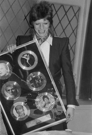 David Bowie holding an award