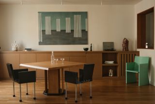 a dining room with wooden furniture and a mint green artwork and chair