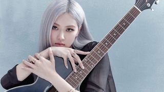 Rosé holding an acoustic guitar