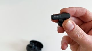 Mustat Huawei Freebuds 5i -nappikuulokkeet ihmisen kädessä