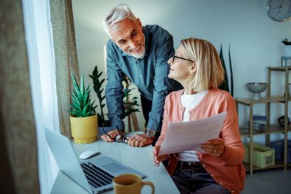 Smiling couple using laptop at home together