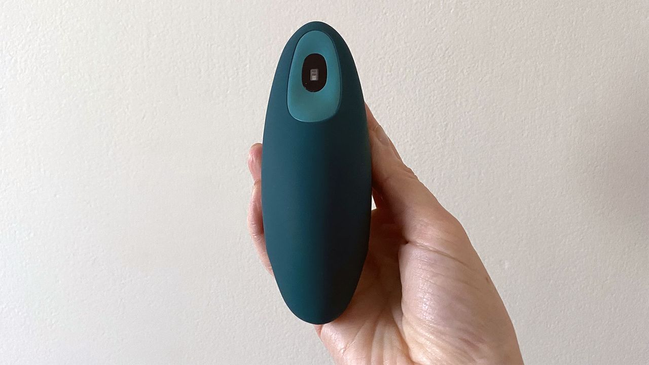The moonbird held in our reviewer's hand with the 'wings' in the exhale position, implying you should be breathing out