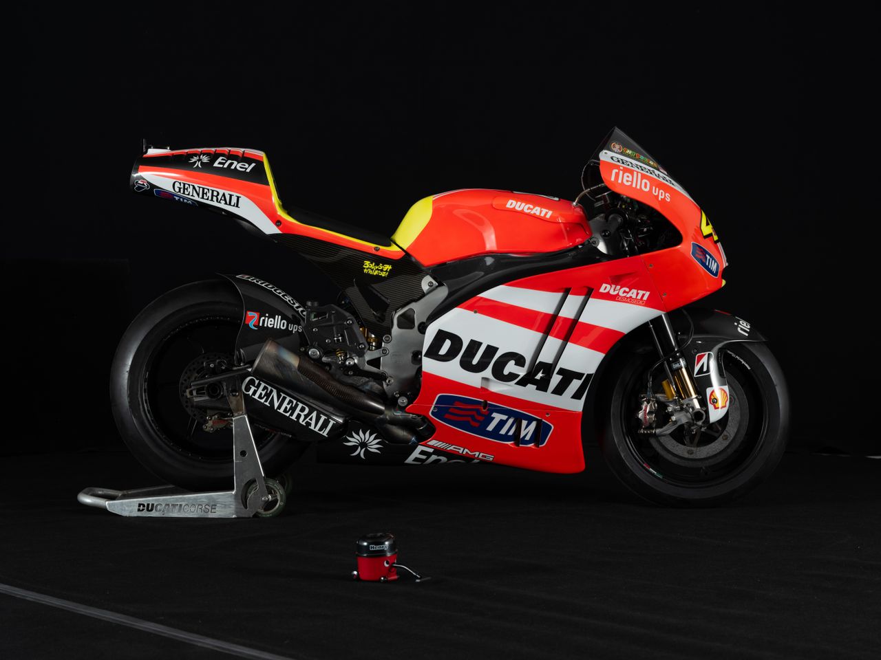 A red Ducati motorbike in a studio