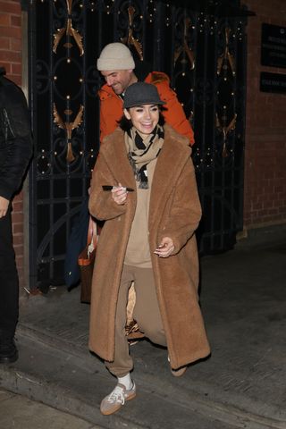 A photo of Lily Collins topping off her teddy coat with a gray felt baseball cap from Jil Sander.