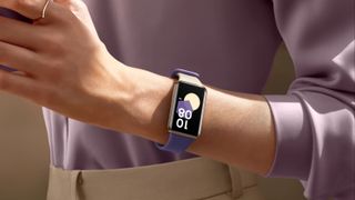 Honor band nine on th wrist of a person wearing a purple shirt