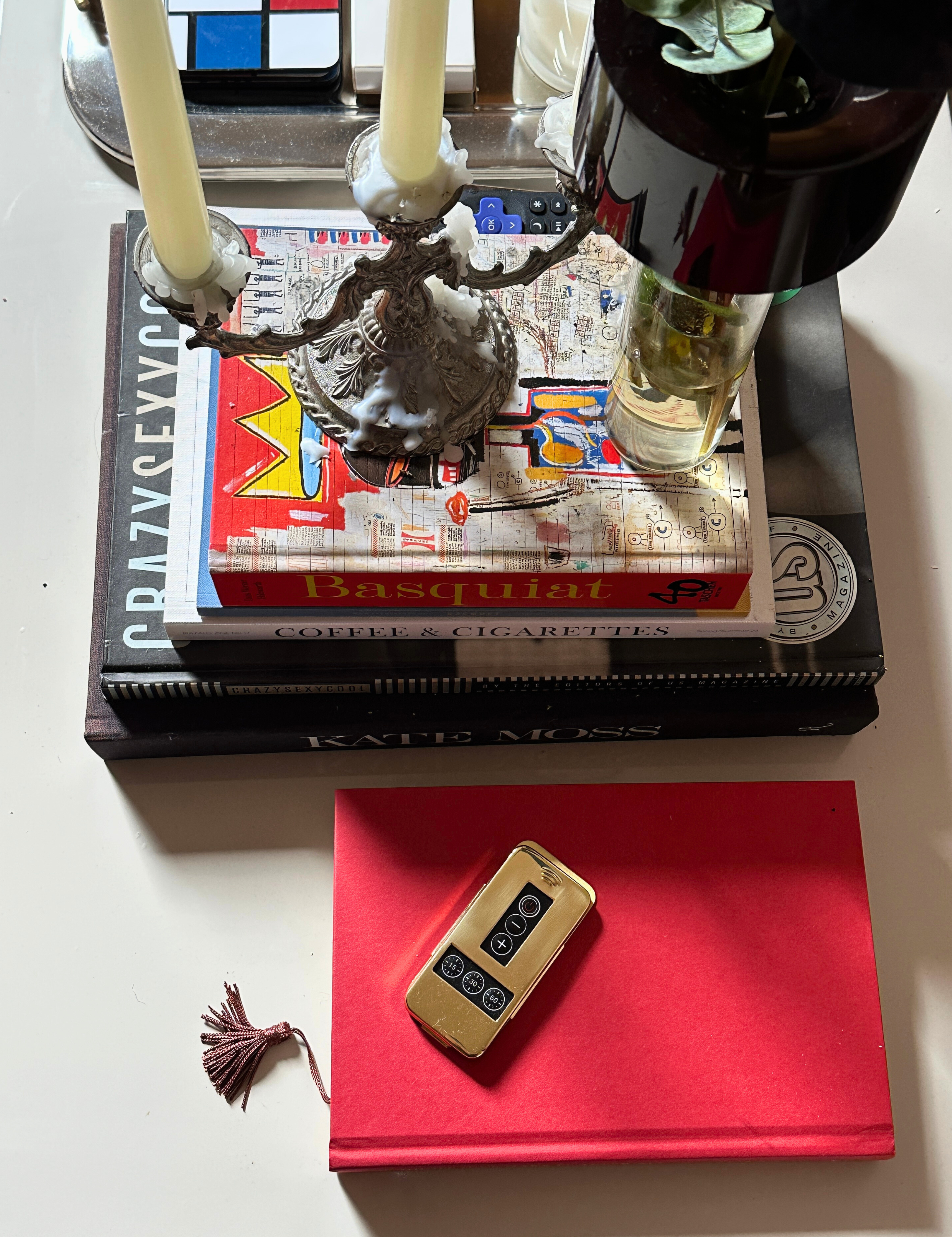 Gold Pooky Lighting remote control sitting atop of a coffee table alongside collected objects