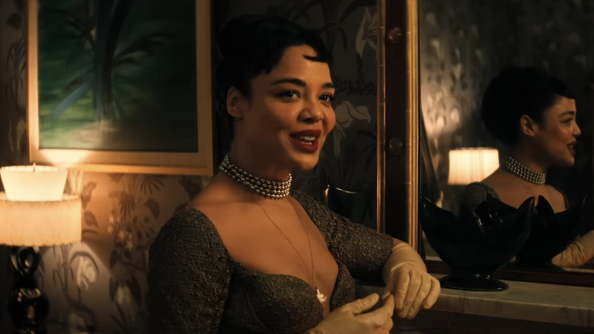 Tessa Thompson smiling while looking across a room in Hedda