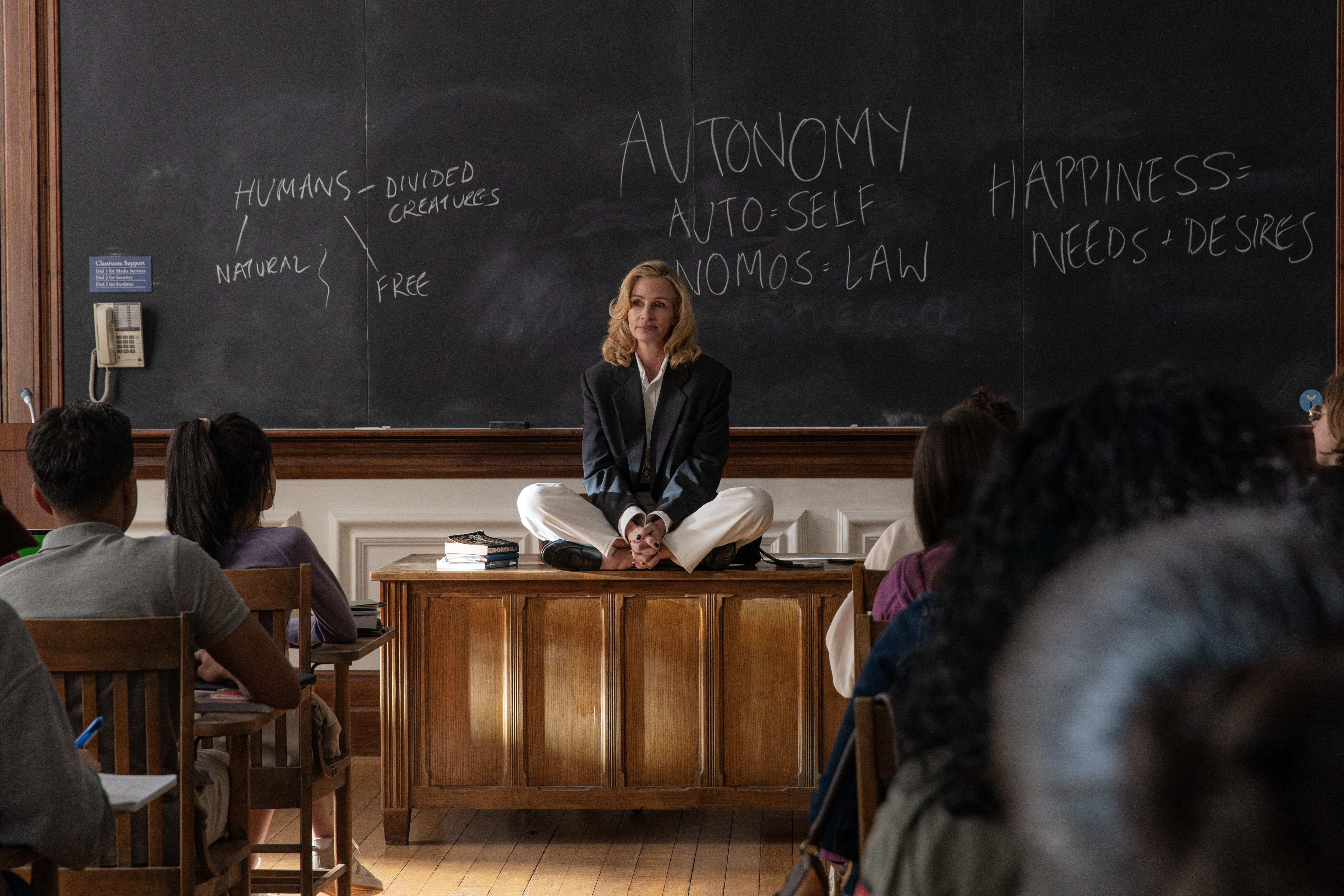 julia roberts as alma sitting on her desk and teaching a class in after the hunt