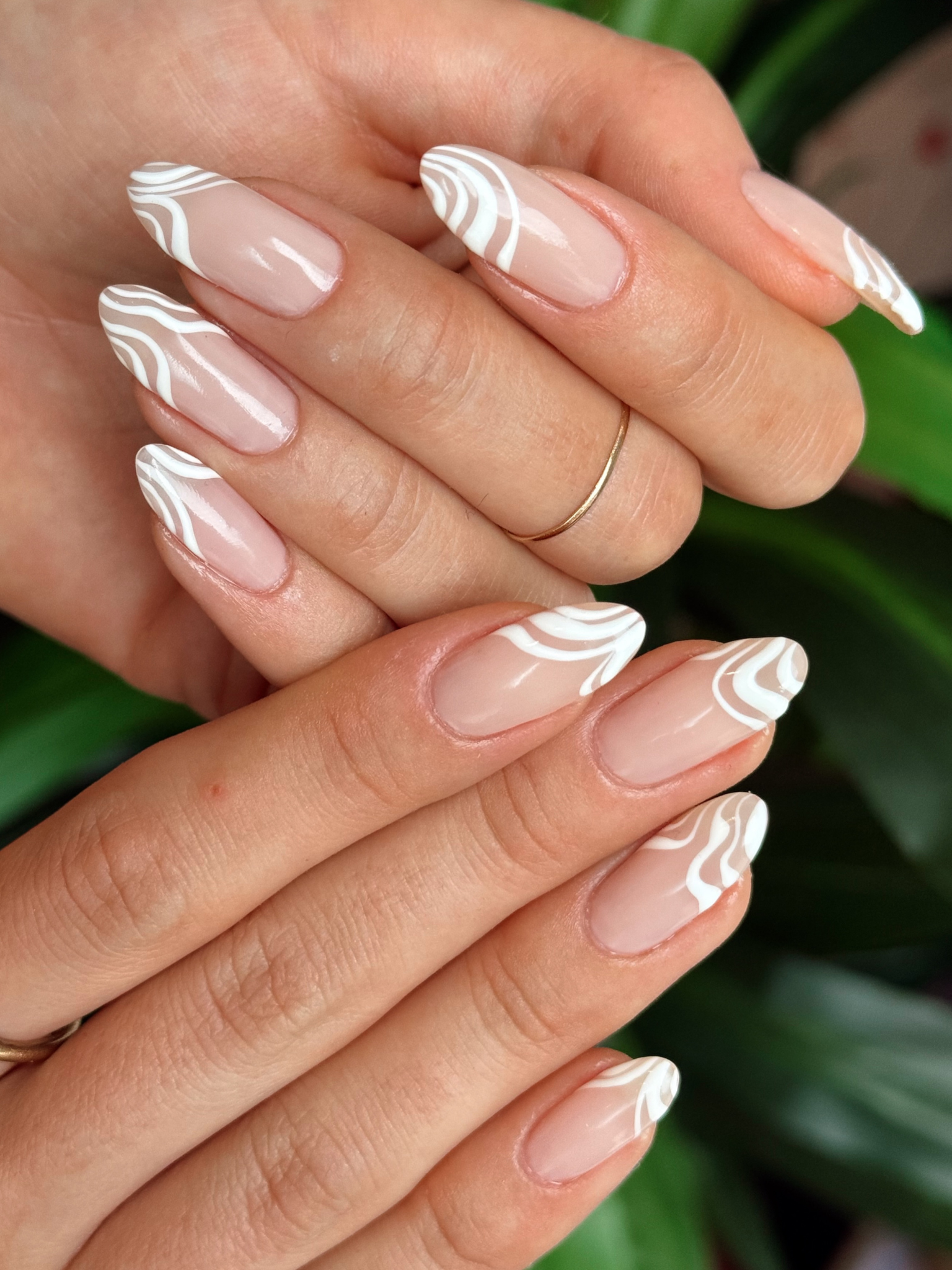 A nail design of white waves on a nude base.