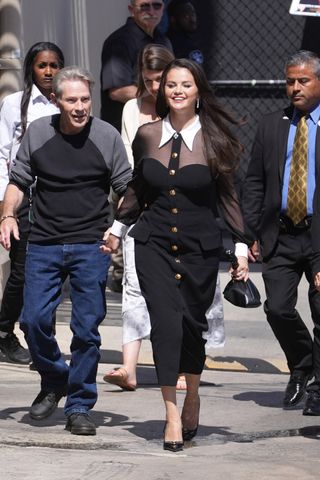Selena Gomez on set for Jimmy Kimmel Live wearing a button up dress and pumps by Versace