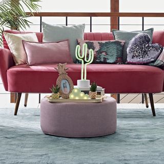 living room with pink sofa cushions and grey rug
