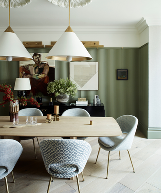 dining area with green panelled walls and dinnig table and chairs and artwork