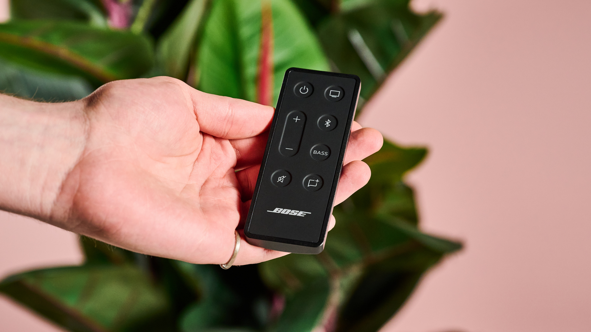 Person holding Bose Solo Soundbar 2 remote