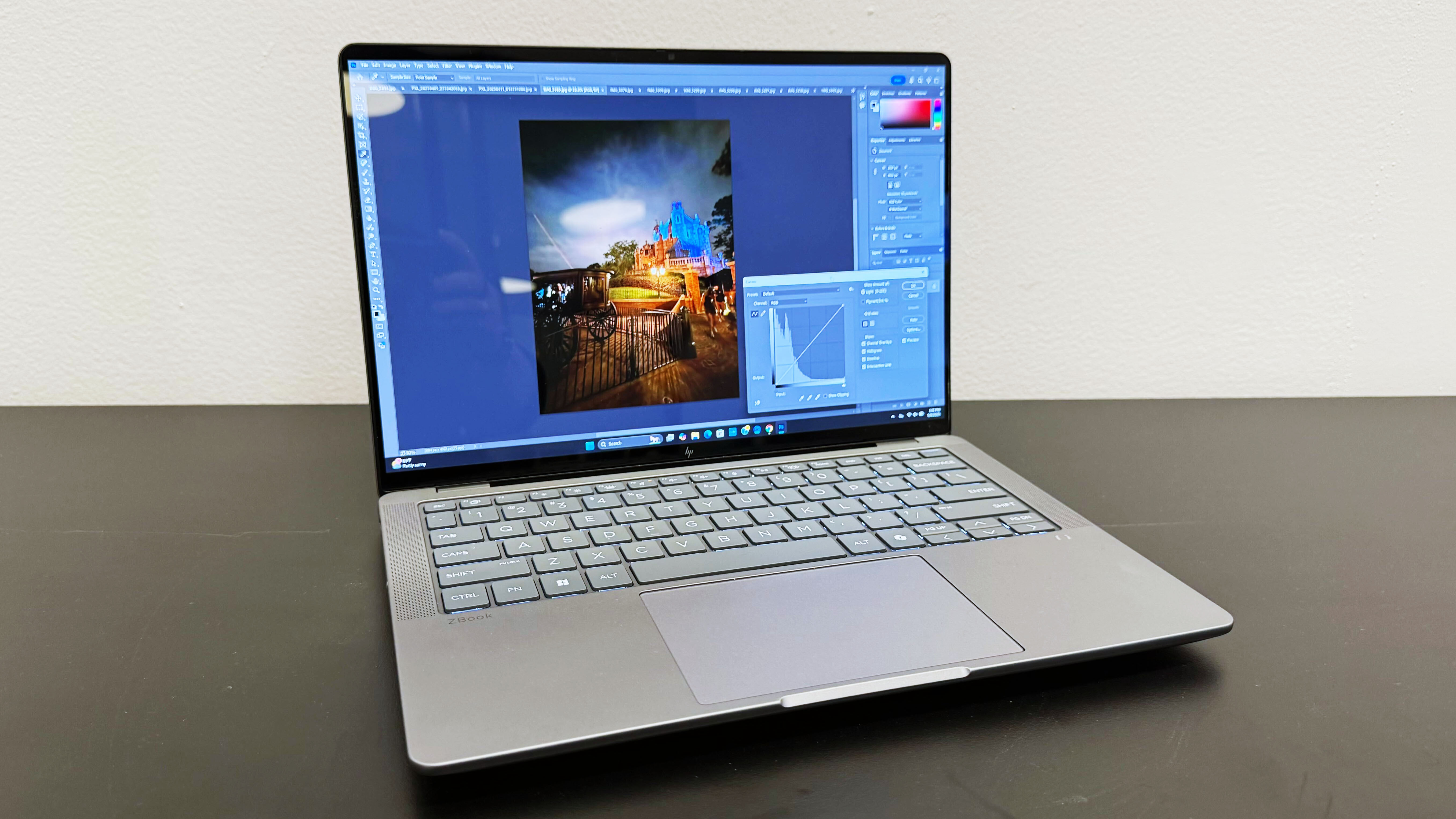 The HP ZBook Ultra 14 G1a mobile workstation open on a black desk against a white wall.
