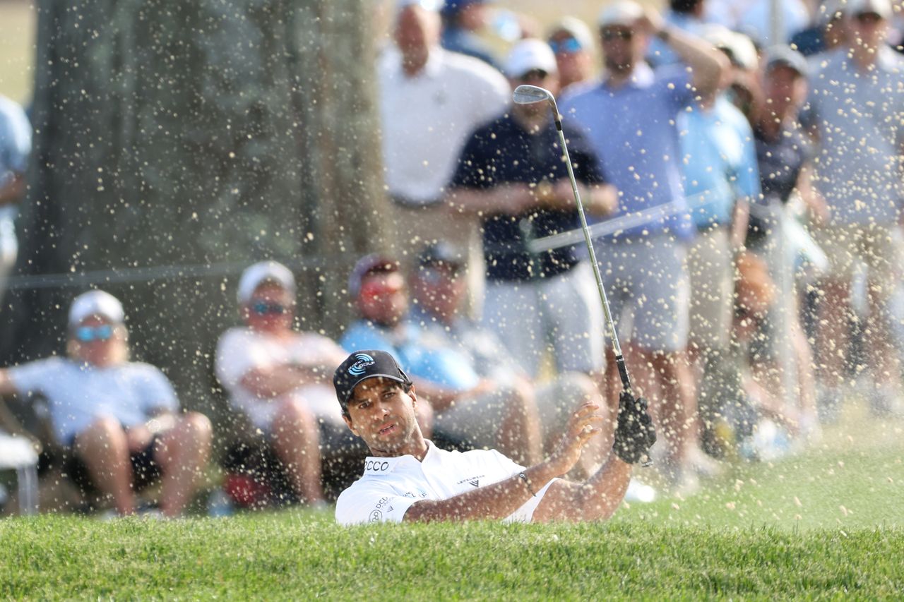 Aaron Rai hits out of a greenside bunker on the 18th hole during the third round of the PGA Championship at Aronimink Golf Club