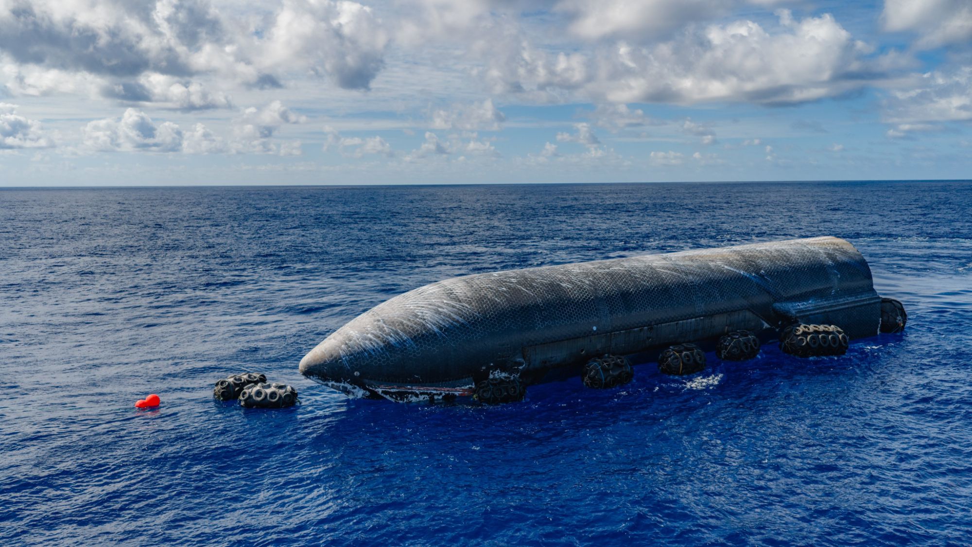 Um foguete gigante e escuro flutua no oceano azul.