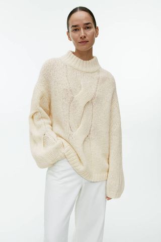 arket sale - woman wearing cream cable knit