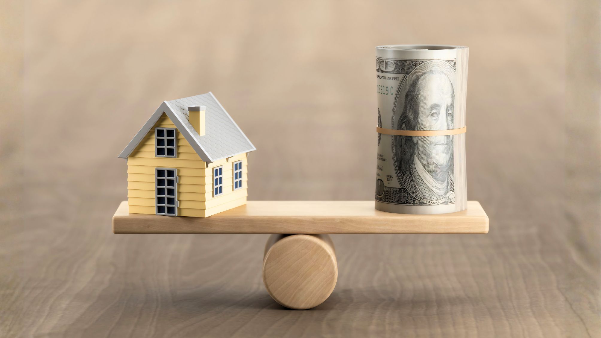Model house and money on the seesaw