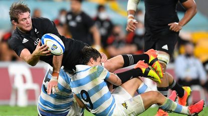 Ethan Blackadder of the All Blacks offloads the ball in a tackle during The Rugby Championship match between the Argentina Pumas and the New Zealand All Blacks at Suncorp Stadium on September 18, 2021