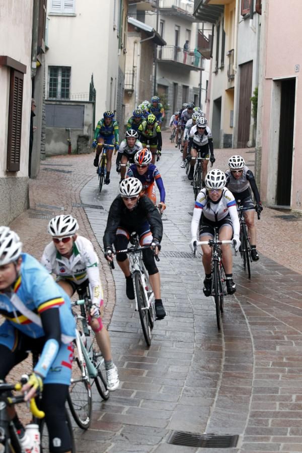 The peloton on the slick roads in a village