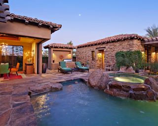 pool with rustic paving and hot tub