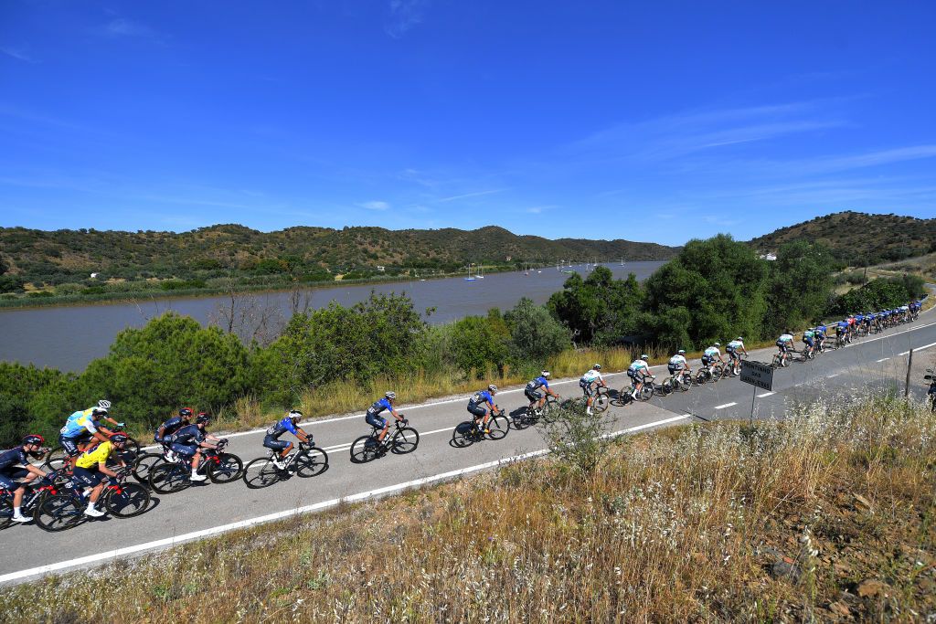 TAVIRA PORTUGAL MAY 07 Ethan Hayter of United Kingdom and Team INEOS Grenadiers Yellow Leader Jersey The Peloton passing through Vale las Laranjeiras and Guadiana river during the 47th Volta Ao Algarve 2021 Stage 3 a 2031km stage from Faro to Tavira VoltAlgarve VAlgarve2021 on May 07 2021 in Tavira Portugal Photo by Luc ClaessenGetty Images