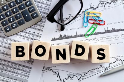 the word bonds written on wooden blocks set atop financial papers