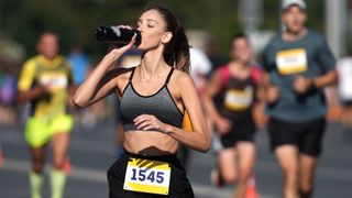 a female runner drinking water during a race