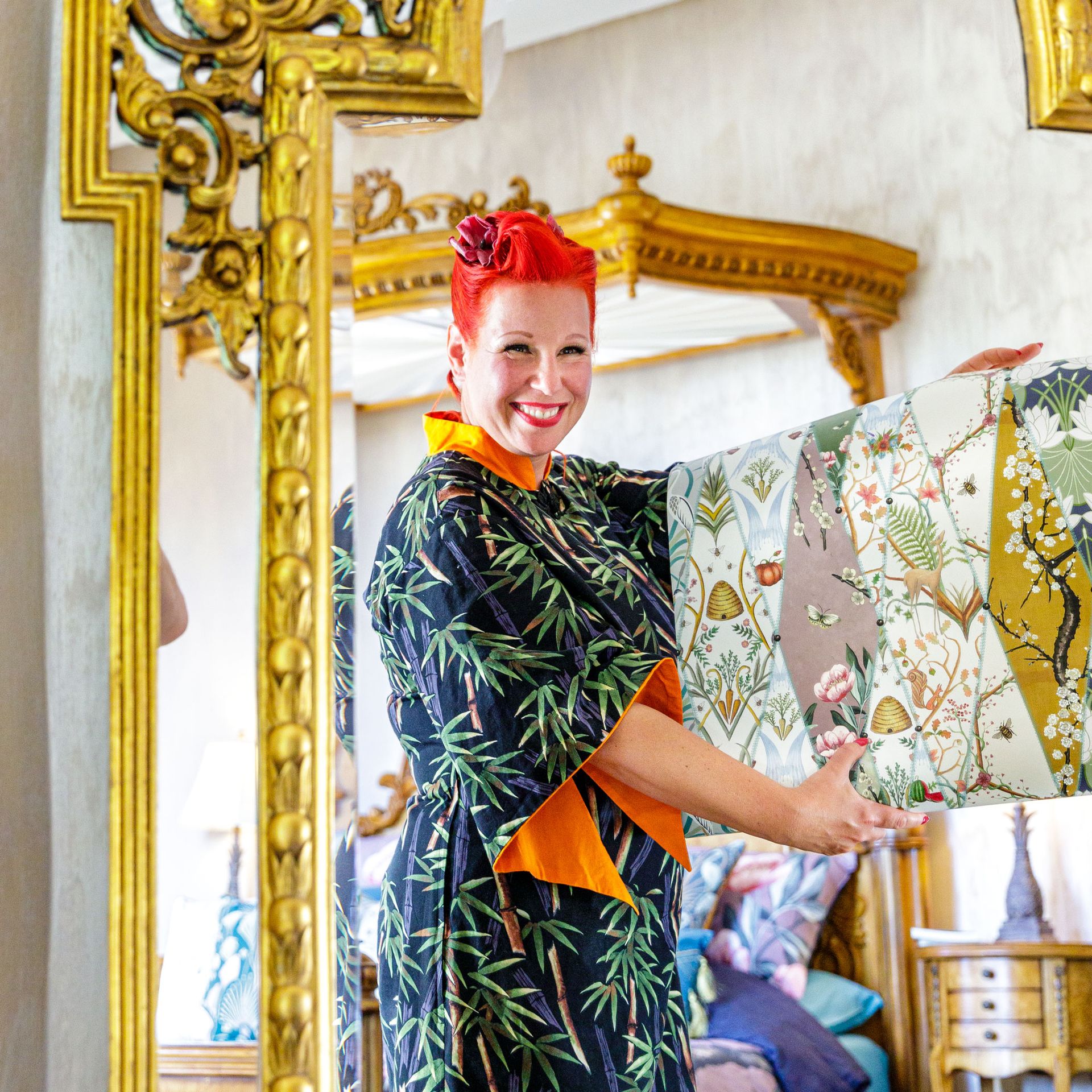 Angel Strawbridge holding rolls of wallpaper that she designed