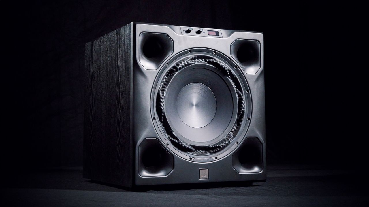 A black Dali V-16 F subwoofer on a black background.