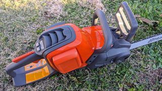 There are handles behind the battery and in front of it so that you can hold the chainsaw with two hands.