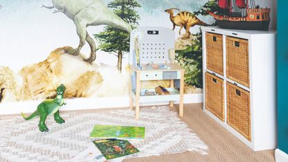 A kids&#039; playroom with storage cubby holes, a dinosaur wallpaper and a toy kitchen