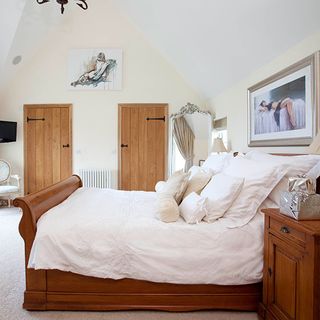 bedroom with with wall wooden bed with white cushions and wooden doors