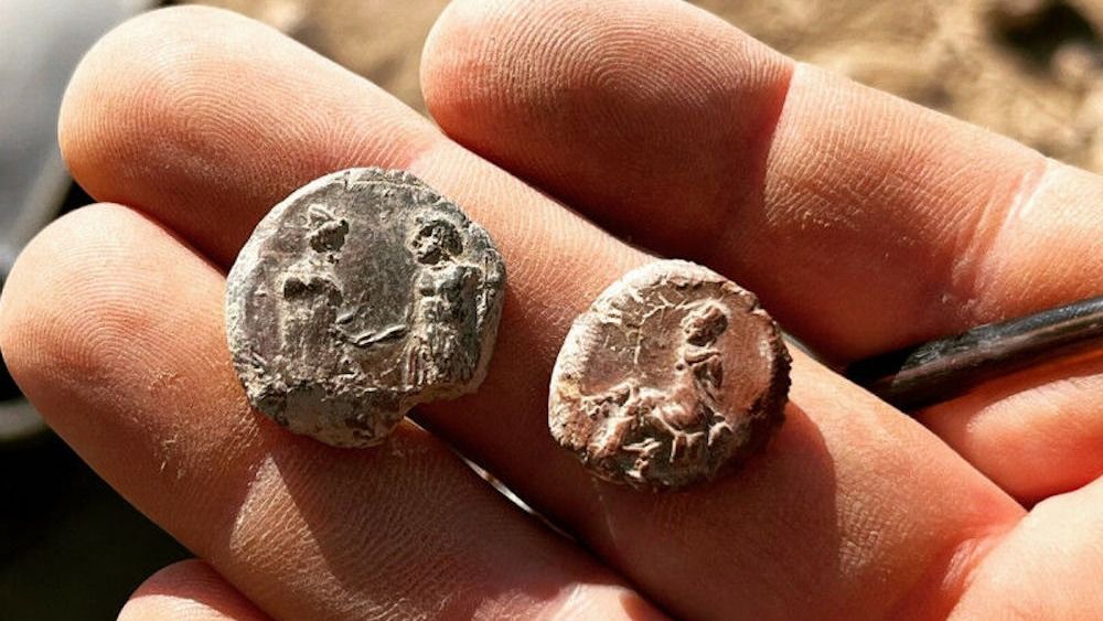 A person holds clay seals in their hand