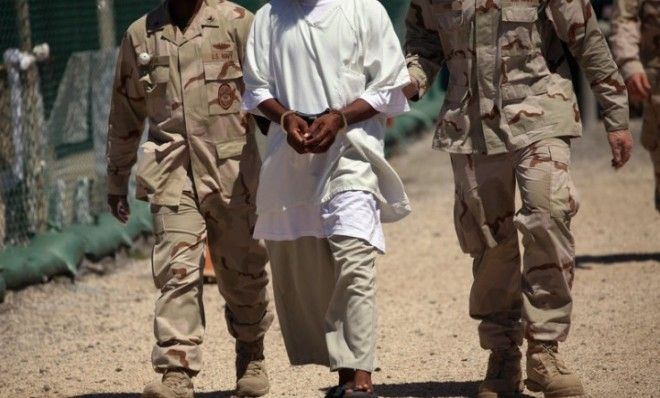 U.S. military guards move a detainee inside Guantanamo in 2010.