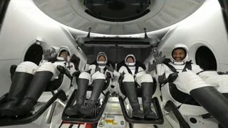 Four Axiom Space Ax-2 astronauts wave inside a SpaceX Dragon capsule after splashdown
