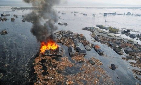 A house is ablaze after tsunami waves rip through a town in northeastern Japan Friday.