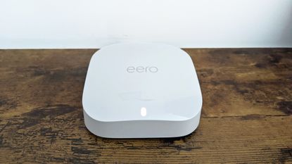 Amazon Eero Pro 6E review: man playing videogame with mesh wi-fi router by his computer