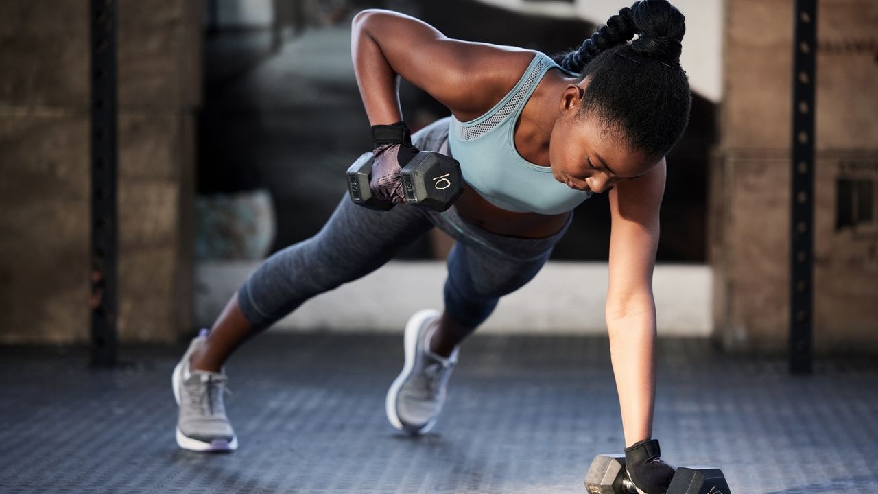 Woman doing a renegade row exercise with dumbbells