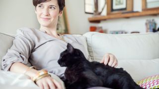 Woman cuddling black cat