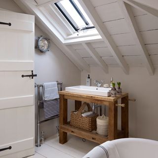 attic bathroom with wooden freestanding sink unit and panelled ceiling