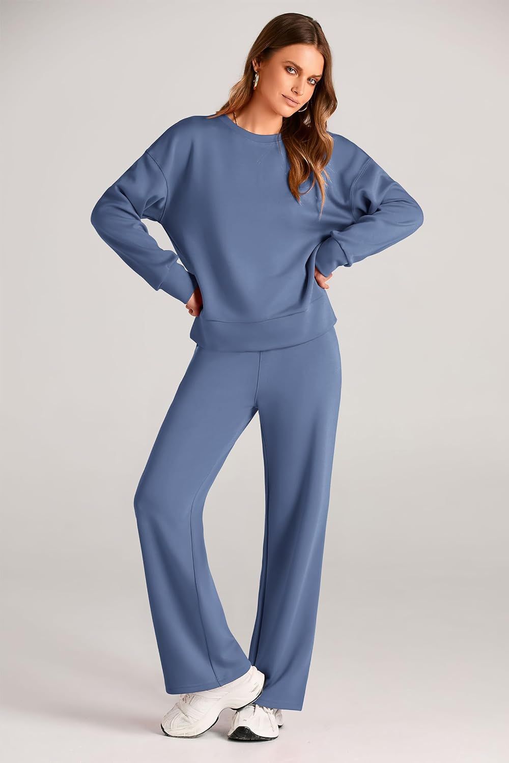 model wears blue sweatsuit and white sneakers